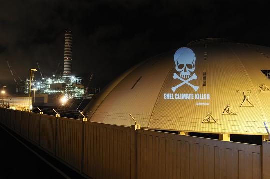 Uno dei messaggi luminosi proiettati nella notte sulla centrale di Torrevaldaliga da Greenpeace - Foto Greenreport